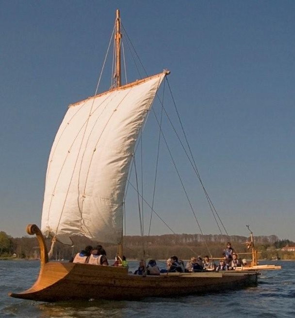 Galley with full sail in front of Church